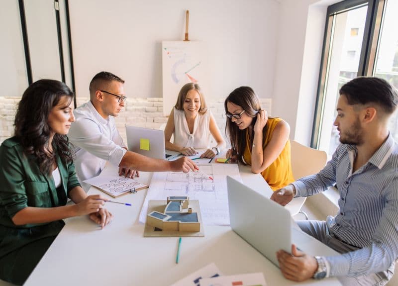 A team weighing the cost of hiring a virtual assistant versus in-house staff